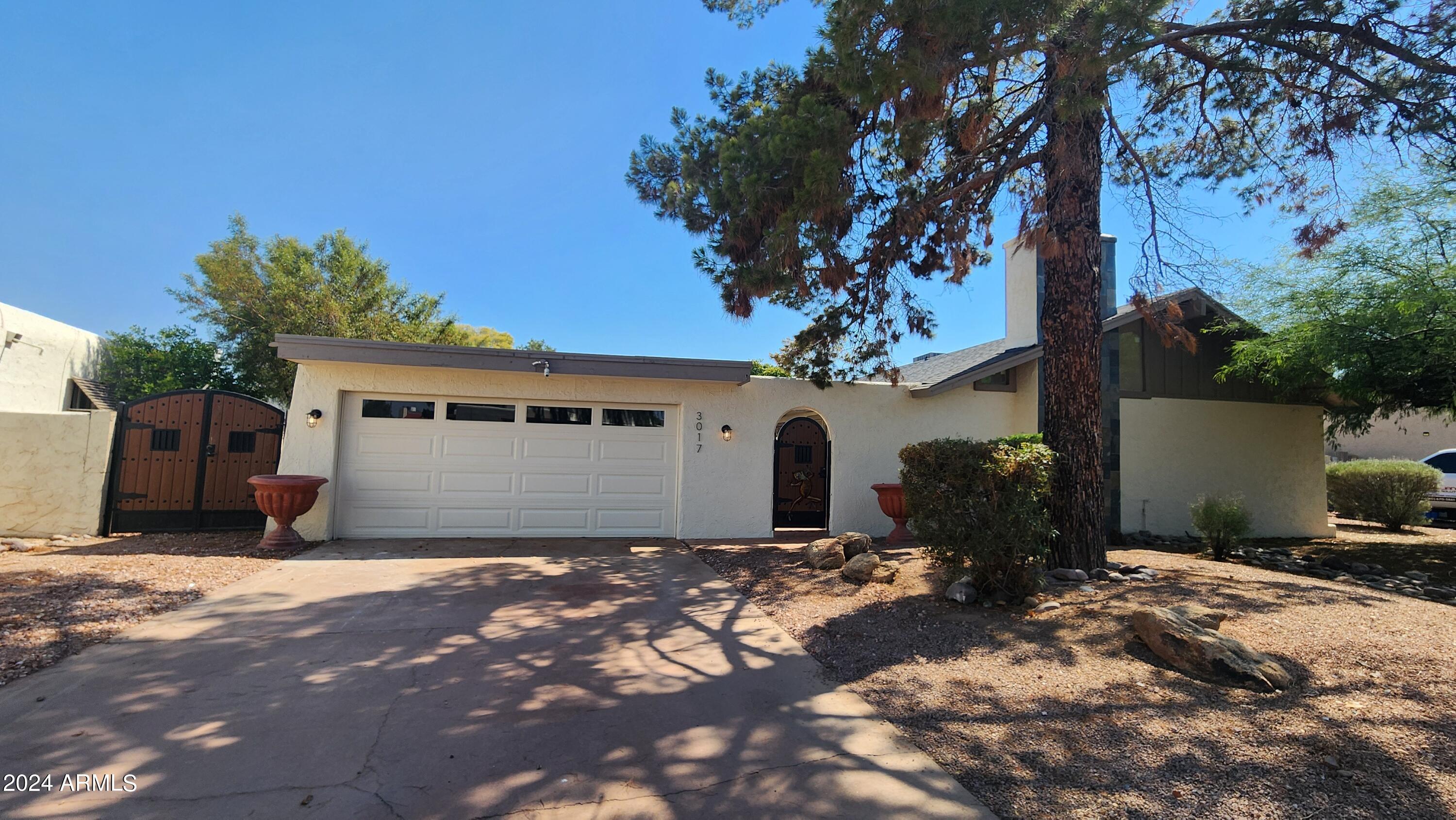 a front view of house with yard and trees in the background