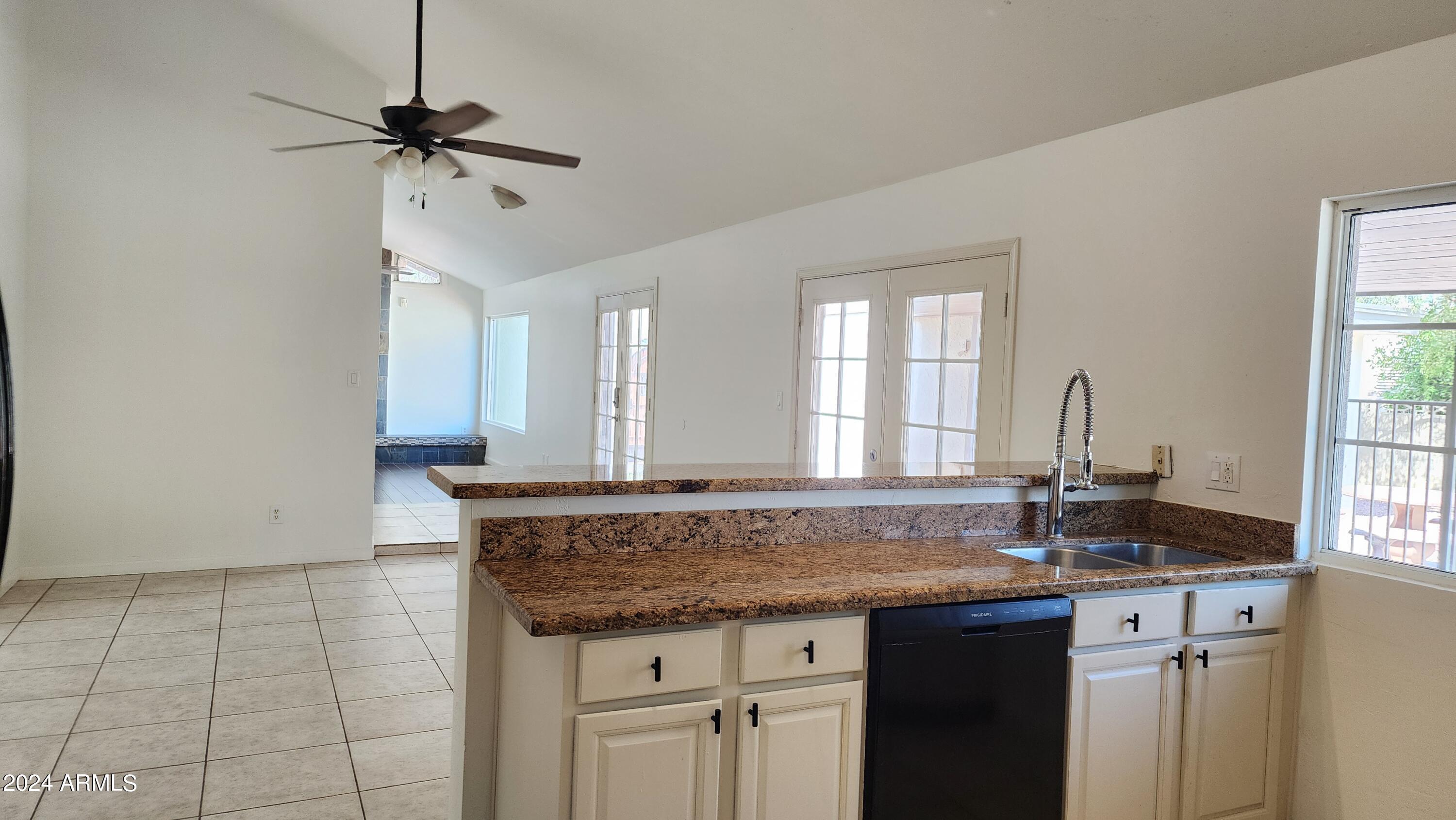 3017 West Yucca Street Phoenix, AZ 85029 - Photo 11 of 32 a kitchen with granite countertop a sink and white cabinets