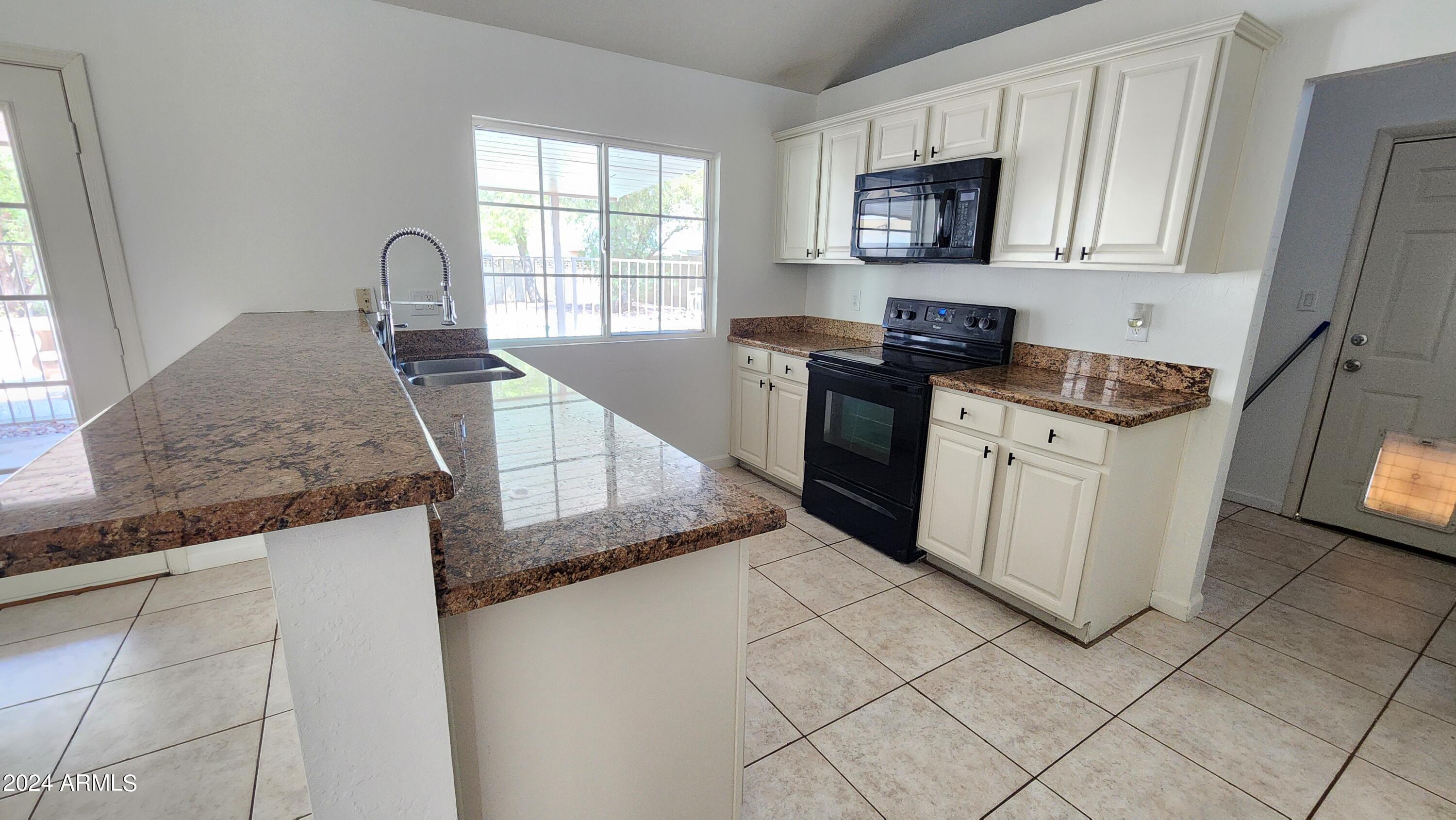 3017 West Yucca Street Phoenix, AZ 85029 - Photo 16 of 32 a kitchen with stainless steel appliances granite countertop a stove a sink and a microwave