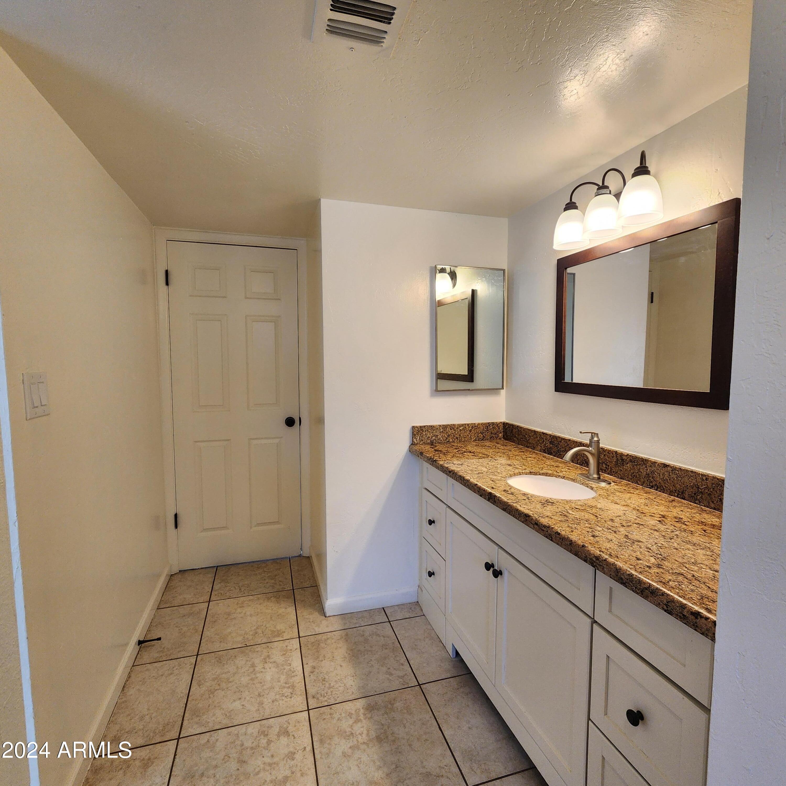 3017 West Yucca Street Phoenix, AZ 85029 - Photo 20 of 32 a bathroom with a granite countertop sink and a mirror