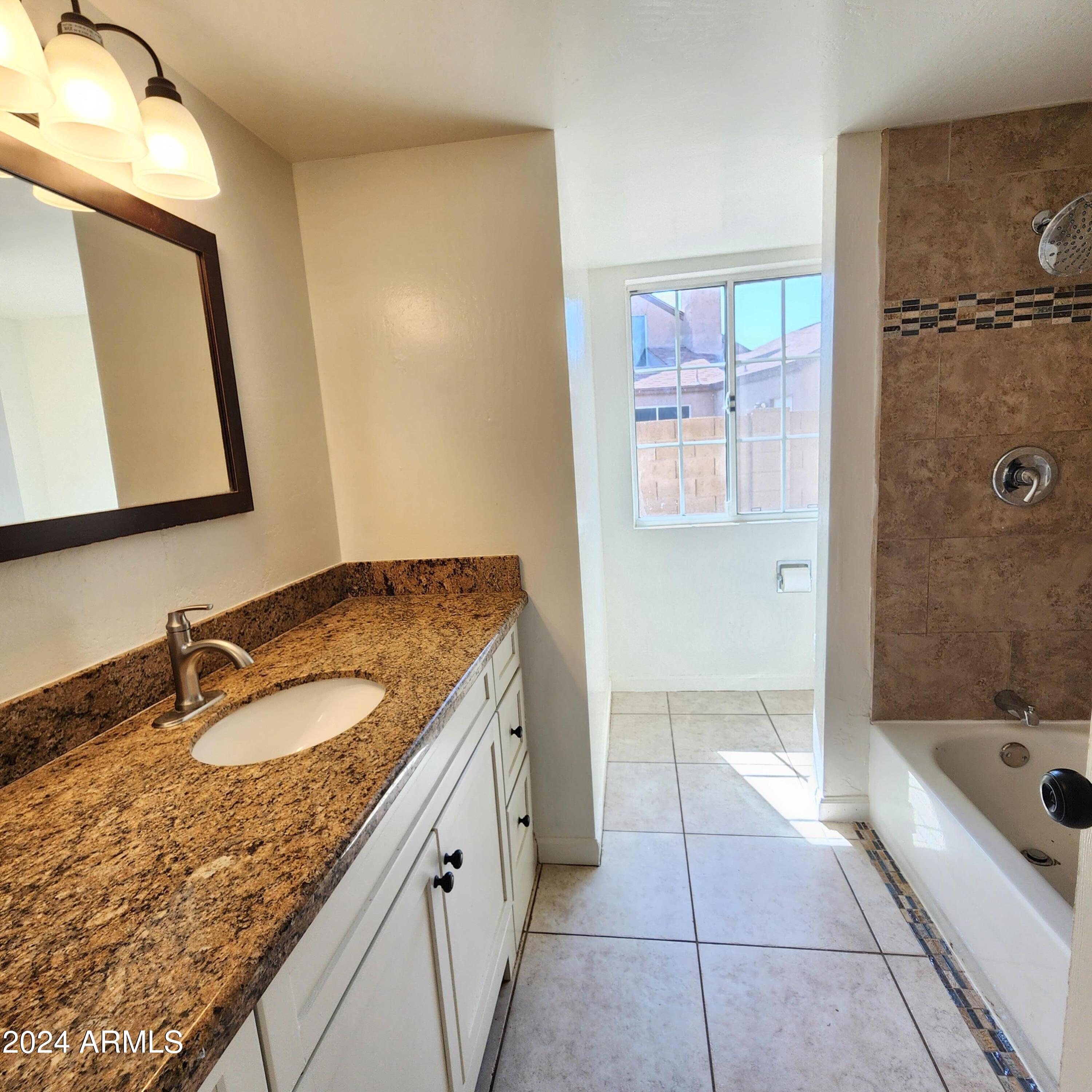3017 West Yucca Street Phoenix, AZ 85029 - Photo 24 of 32 a bathroom with a granite countertop sink a mirror and a bathtub