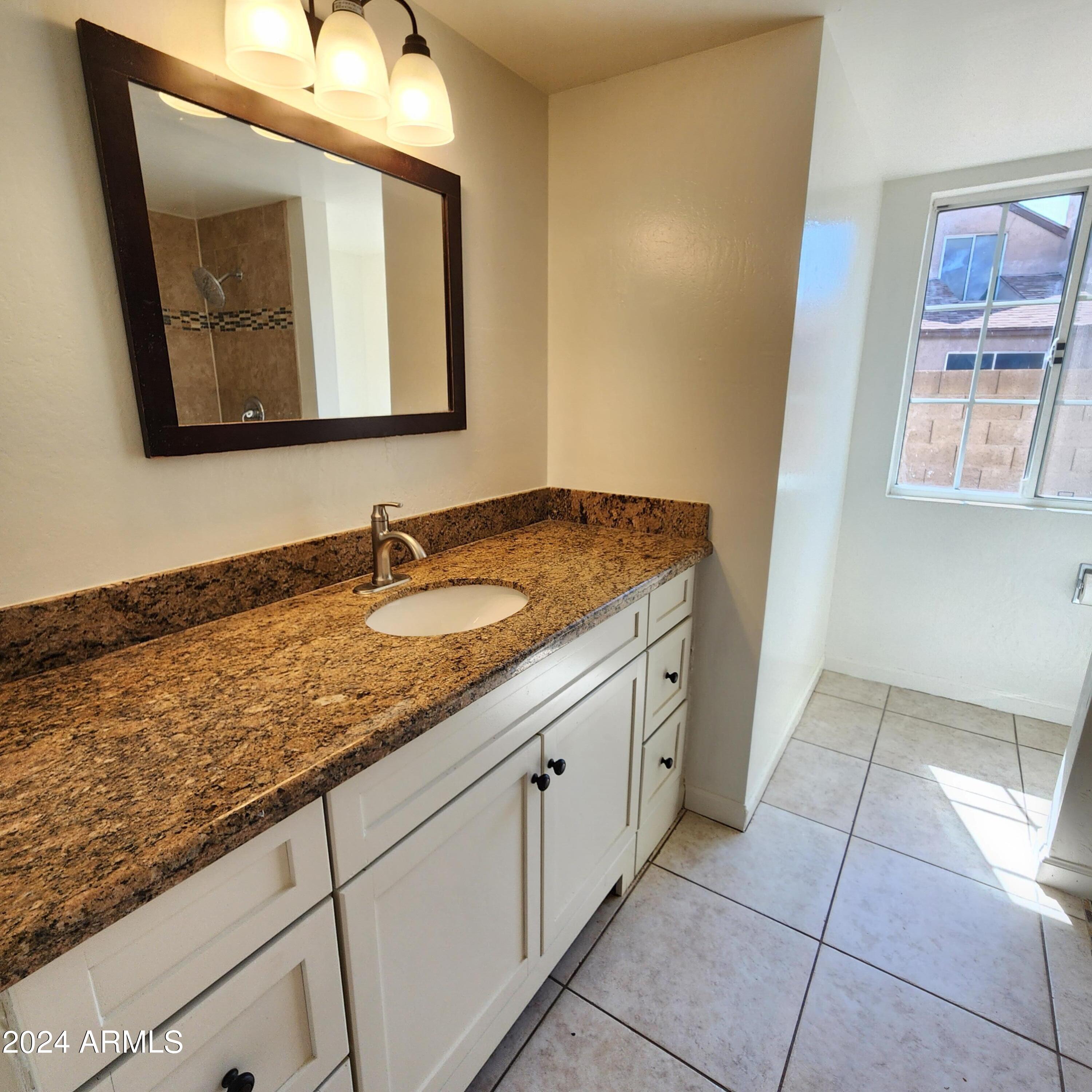 3017 West Yucca Street Phoenix, AZ 85029 - Photo 25 of 32 a bathroom with a granite countertop sink and a mirror