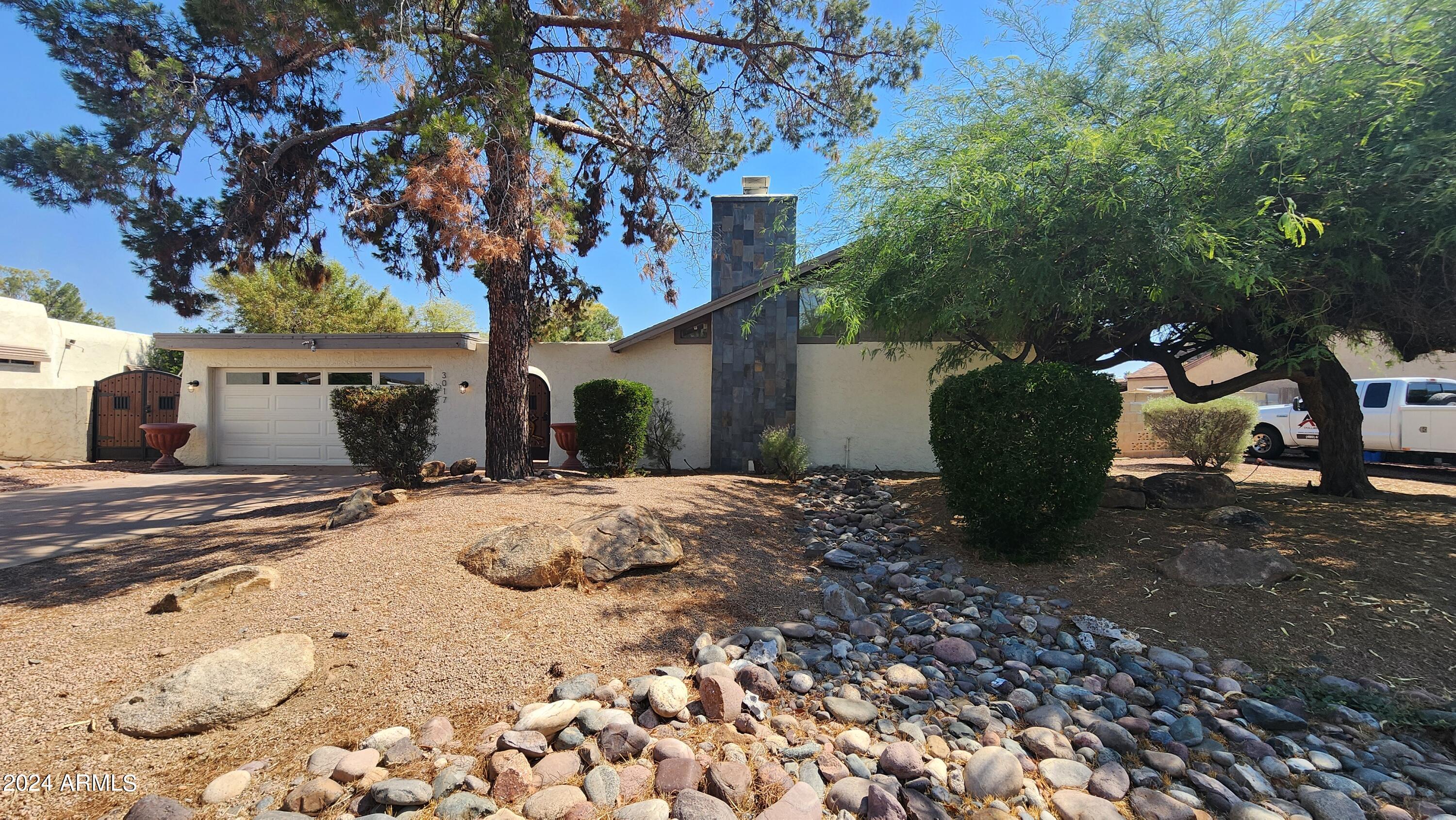 3017 West Yucca Street Phoenix, AZ 85029 - Photo 4 of 32 a view of a backyard with table and chairs under a large tree