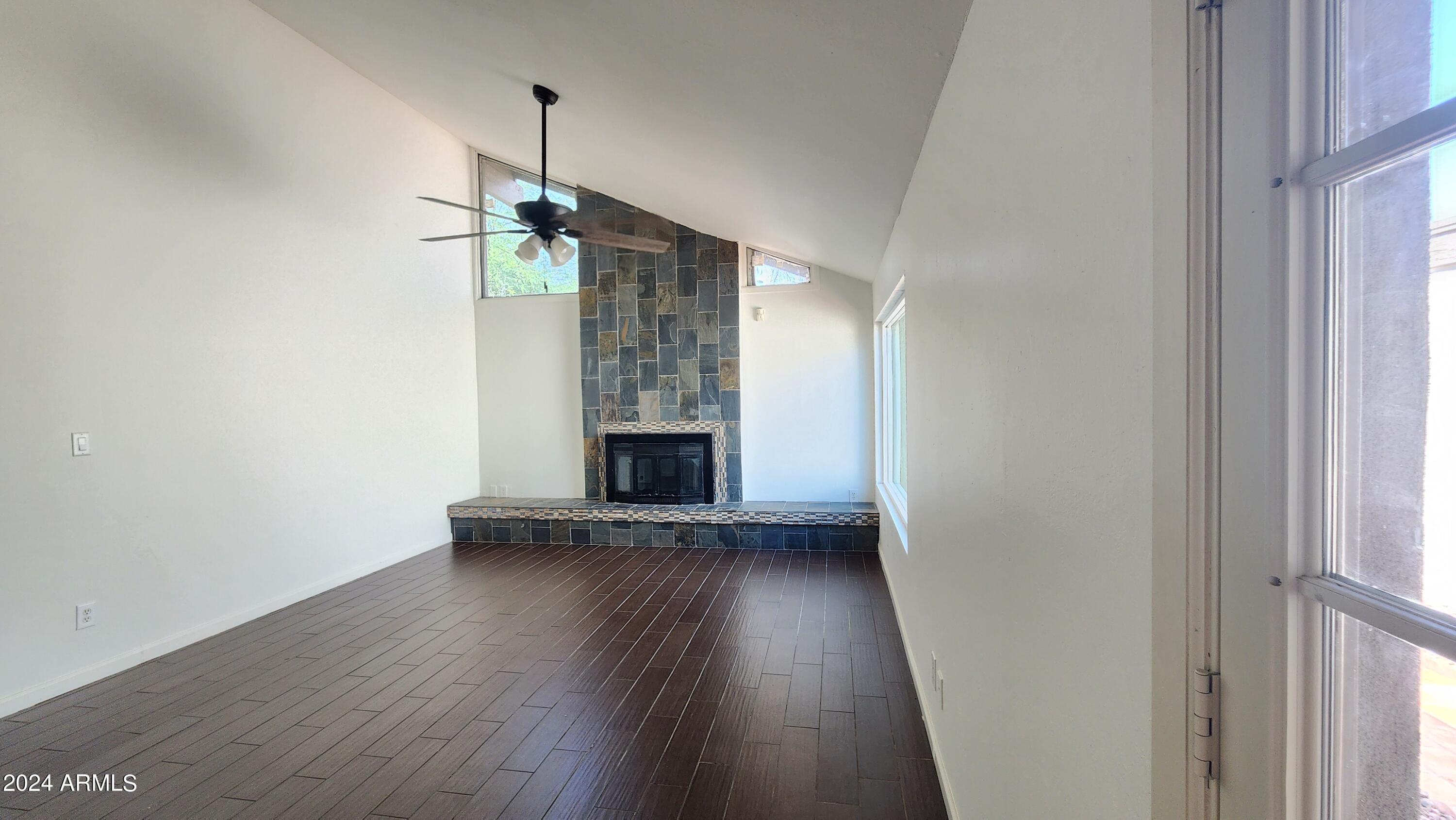 3017 West Yucca Street Phoenix, AZ 85029 - Photo 9 of 32 an empty room with wooden floor and fireplace