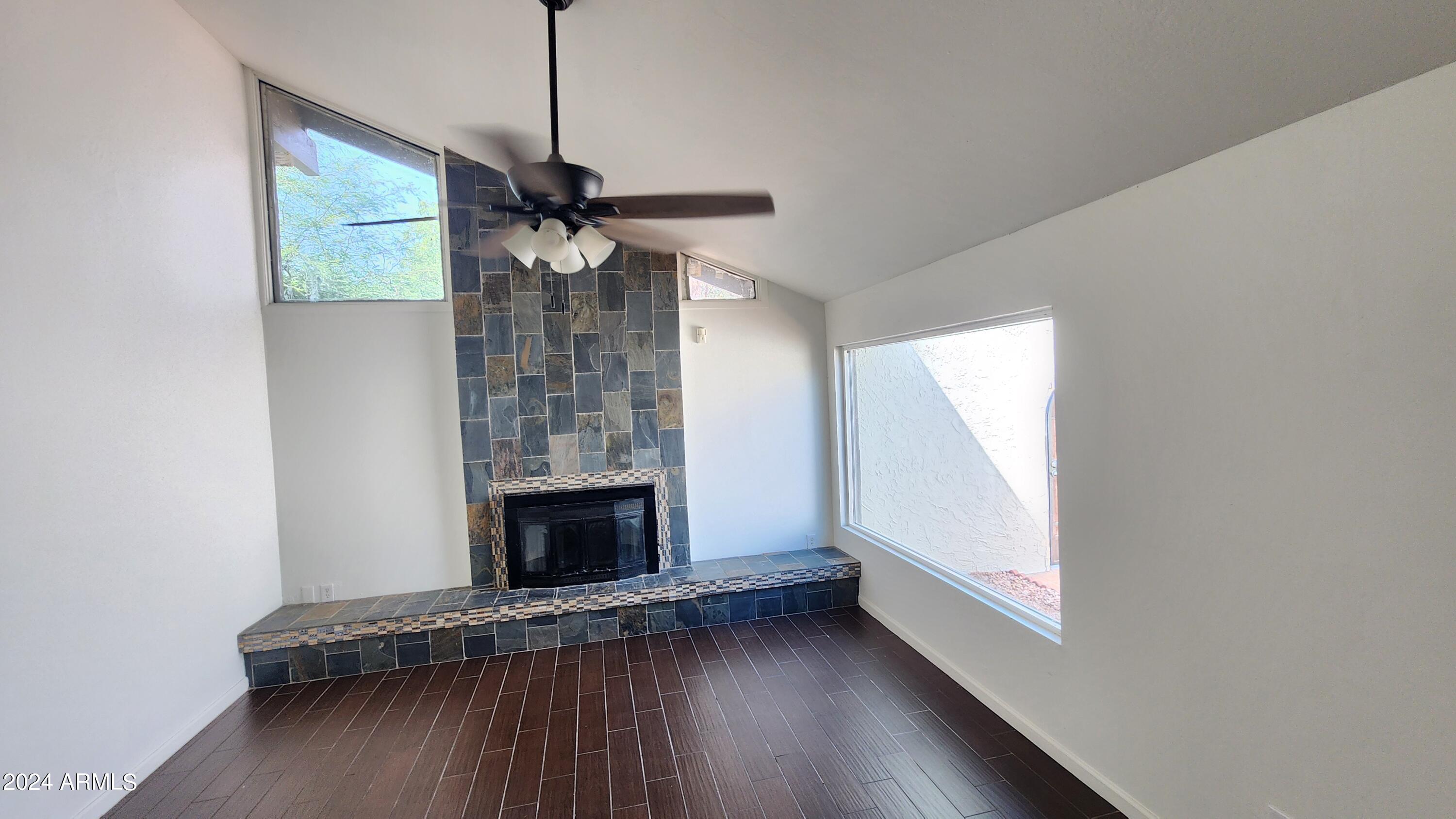 3017 West Yucca Street Phoenix, AZ 85029 - Photo 10 of 32 a view of empty room with wooden floor and fireplace