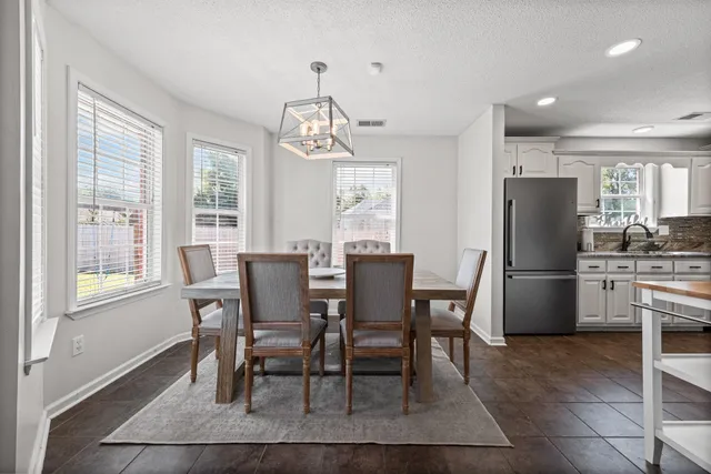 a view of a dining room with furniture a chandelier and wooden floor