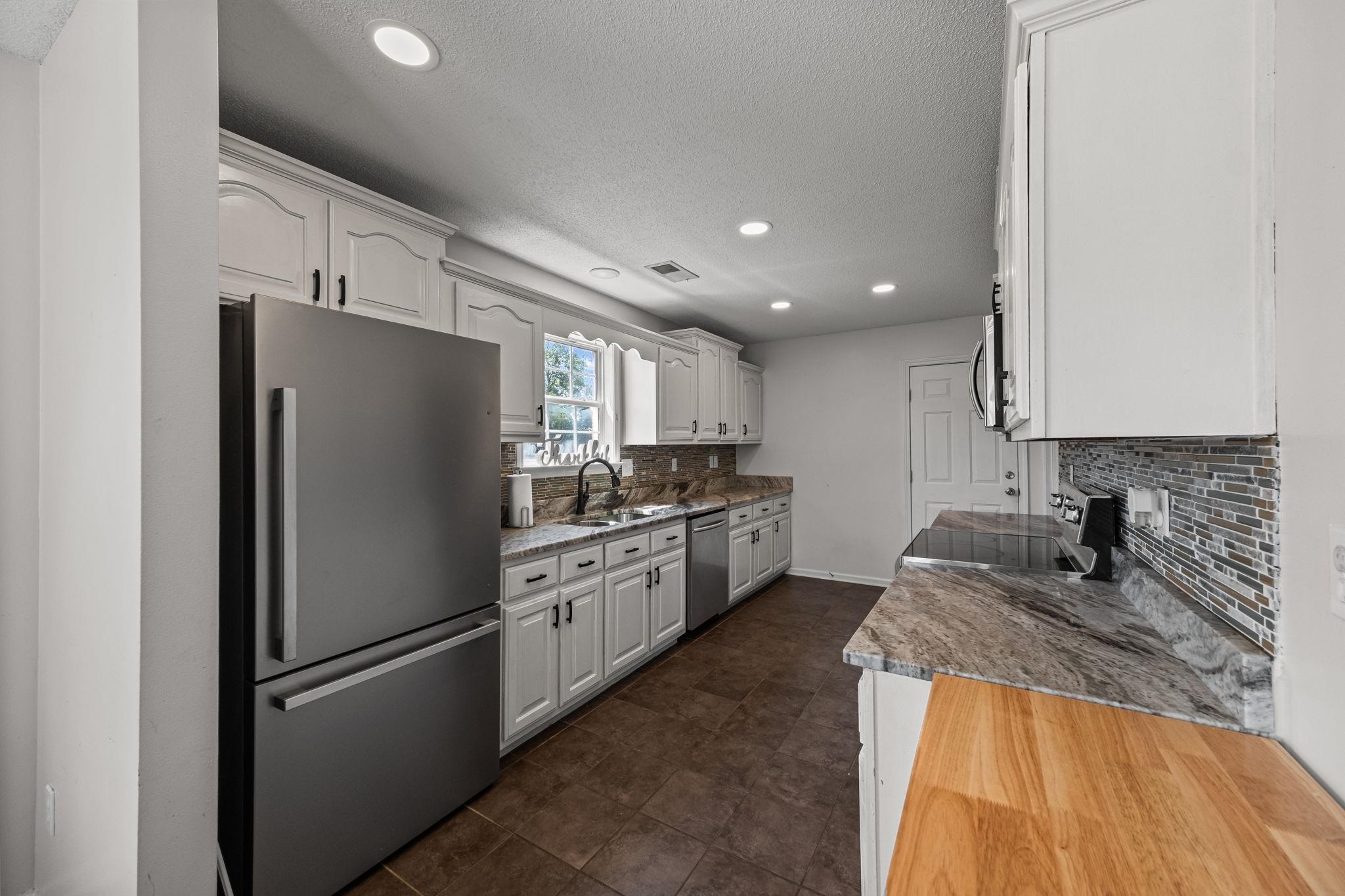 256 Azalea Drive Atoka, TN 38004 - Photo 13 of 39 Kitchen featuring stainless steel appliances, tasteful backsplash, recessed lighting, a textured ceiling, and white cabinetry