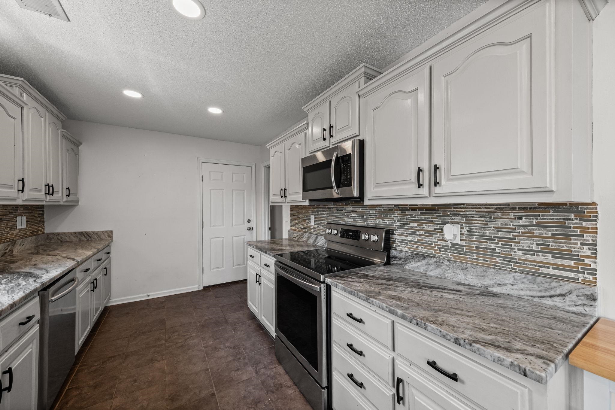 256 Azalea Drive Atoka, TN 38004 - Photo 16 of 39 Kitchen featuring appliances with stainless steel finishes, decorative backsplash, a textured ceiling, recessed lighting, and white cabinetry