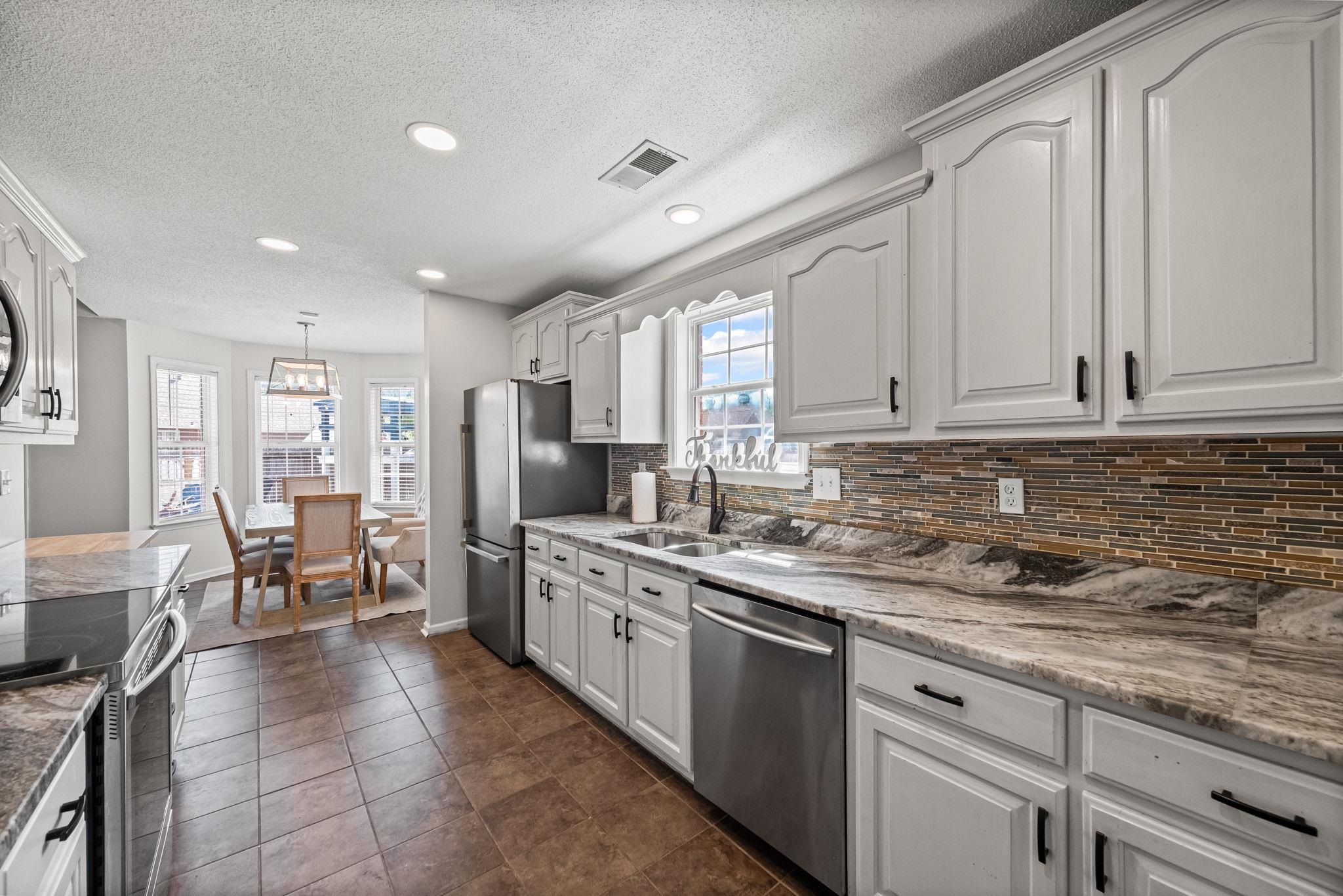 256 Azalea Drive Atoka, TN 38004 - Photo 17 of 39 Kitchen with tasteful backsplash, appliances with stainless steel finishes, white cabinets, recessed lighting, and a textured ceiling