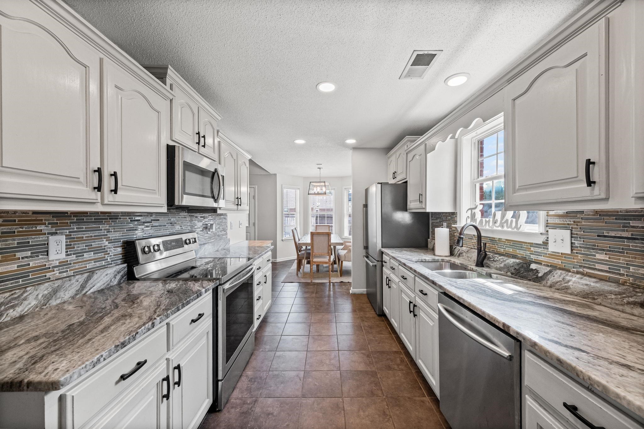 256 Azalea Drive Atoka, TN 38004 - Photo 19 of 39 Kitchen with stainless steel appliances, plenty of natural light, white cabinets, recessed lighting, and backsplash
