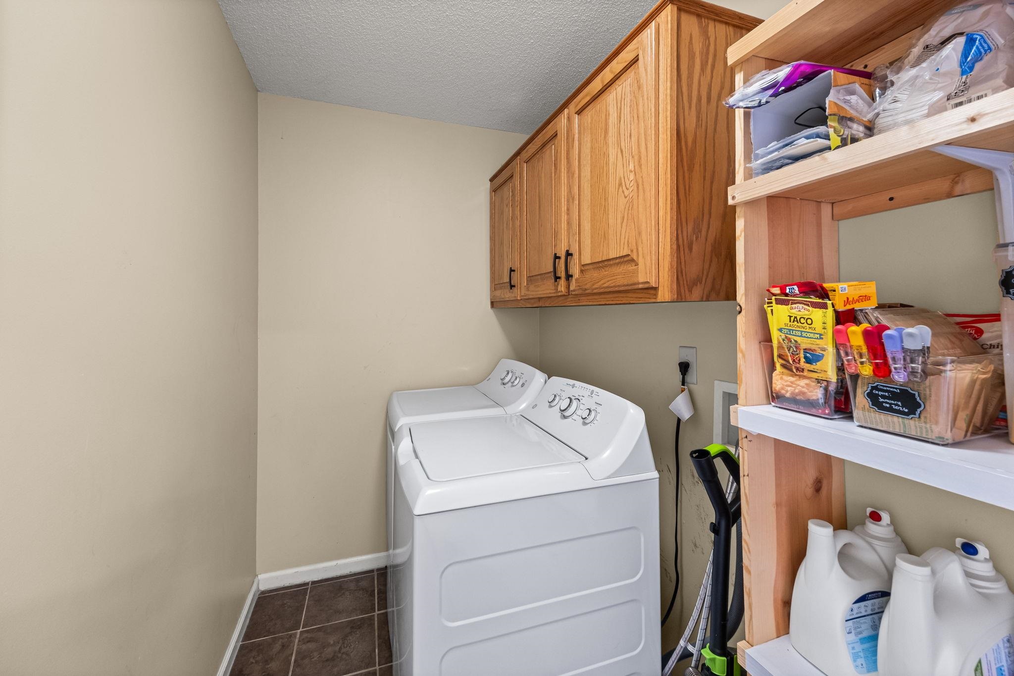 256 Azalea Drive Atoka, TN 38004 - Photo 20 of 39 Washroom featuring cabinet space, independent washer and dryer, tile patterned flooring, and a textured ceiling