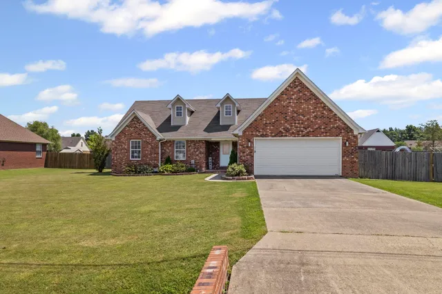 a front view of a house with a garden and yard
