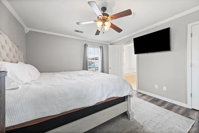 a spacious bedroom with a bed and a flat screen tv