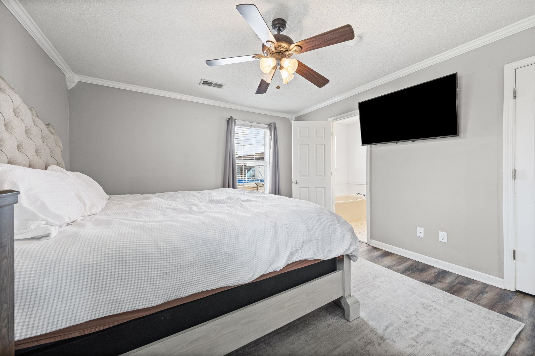 256 Azalea Drive Atoka, TN 38004 - Photo 22 of 39 Bedroom with wood finished floors, crown molding, ensuite bath, and ceiling fan