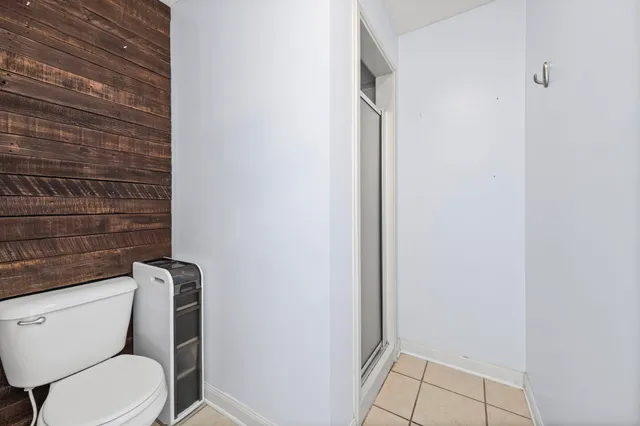 a white toilet sitting next to a shower