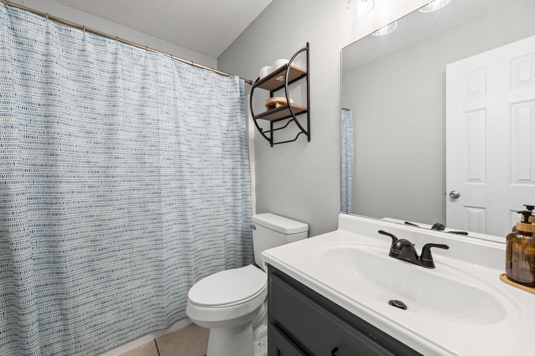 256 Azalea Drive Atoka, TN 38004 - Photo 28 of 39 Full bathroom with vanity, a textured ceiling, tile patterned flooring, and a shower with curtain