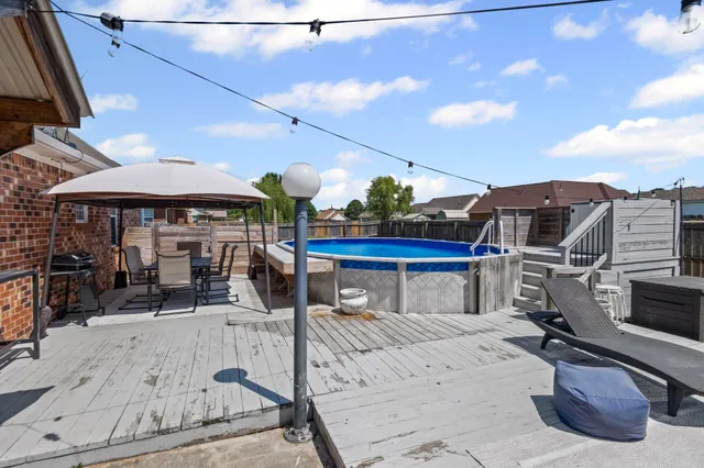 a view of a patio with a table and chairs under an umbrella