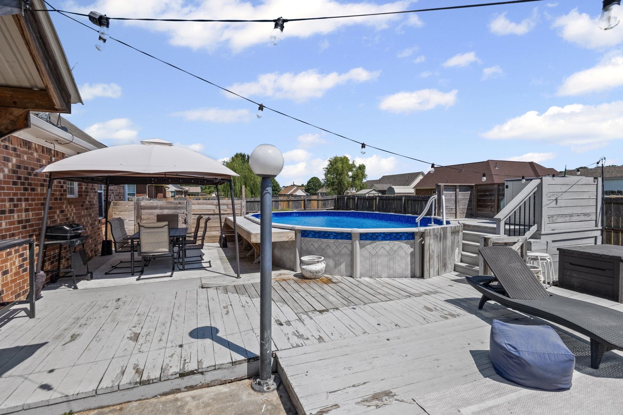 256 Azalea Drive Atoka, TN 38004 - Photo 31 of 39 View of pool featuring a gazebo, outdoor dining area, a deck, and a fenced backyard