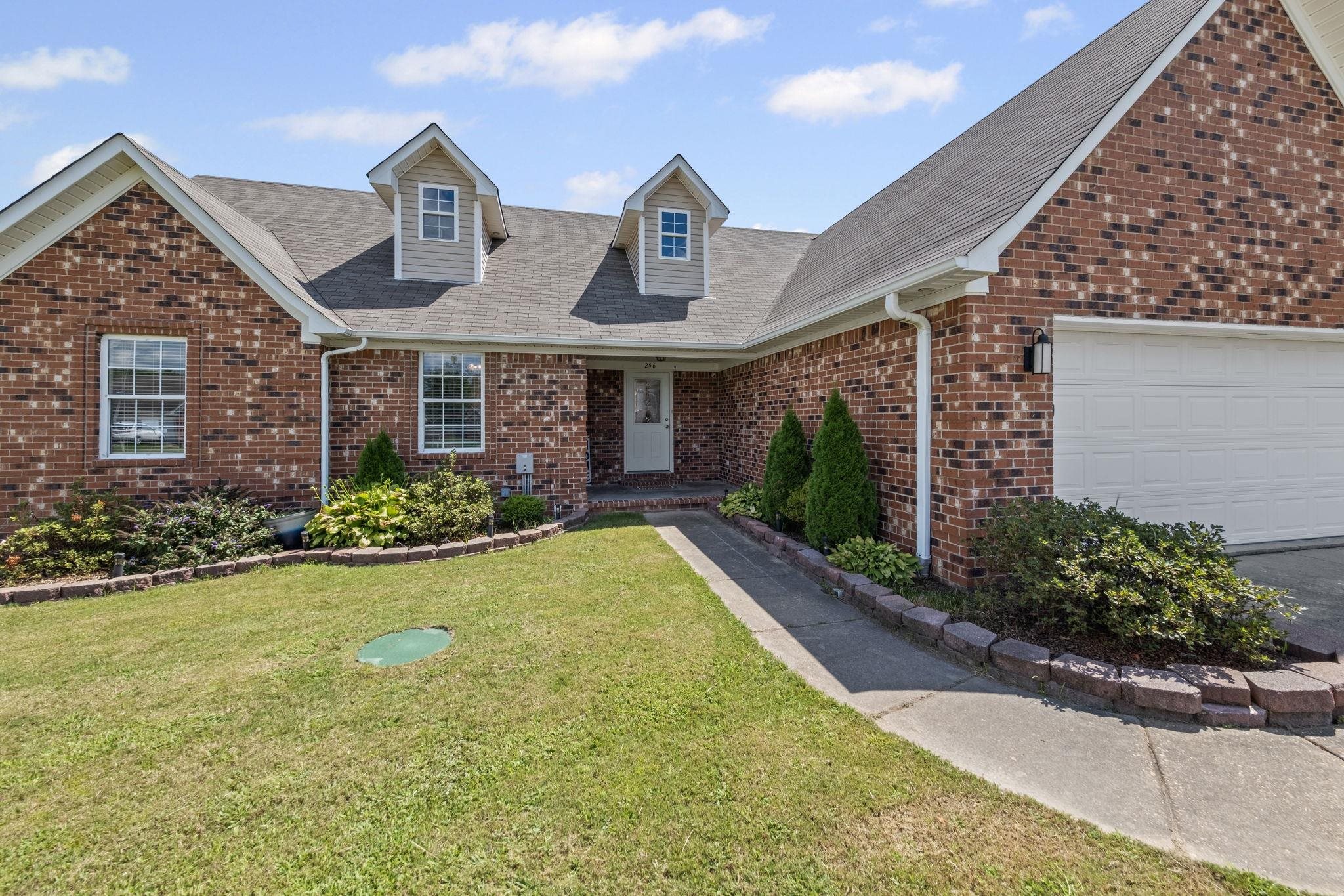 256 Azalea Drive Atoka, TN 38004 - Photo 6 of 39 View of front of home featuring brick siding, a front yard, roof with shingles, and an attached garage