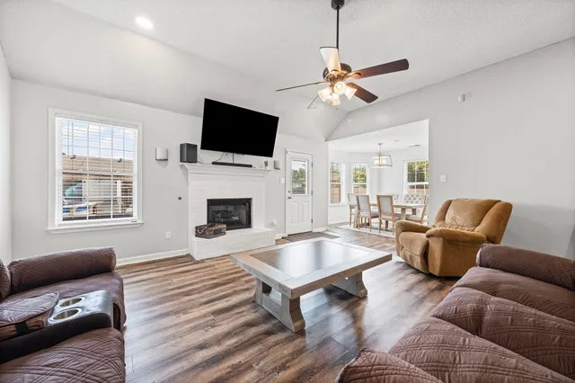 a living room with furniture a flat screen tv and a fireplace