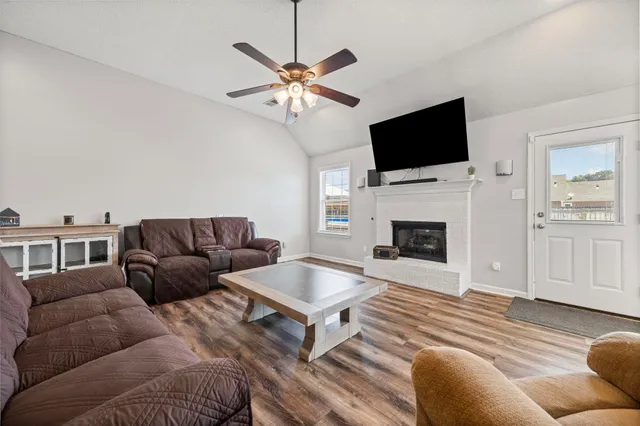 a living room with furniture a flat screen tv and a fireplace