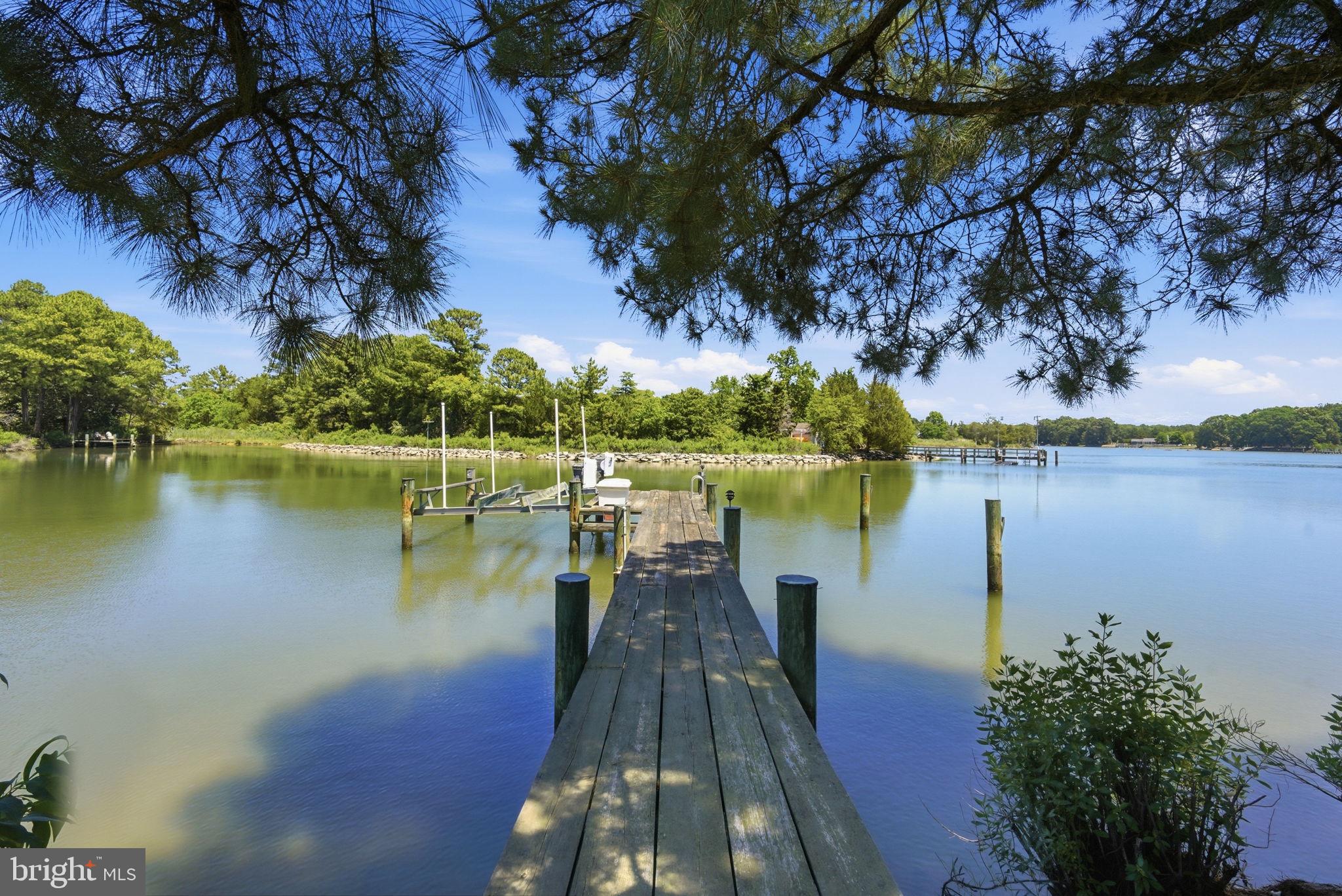 26226 Langs Landing Road Oxford, MD 21654 - Photo 5 of 48 a view of a lake with sitting area and large trees