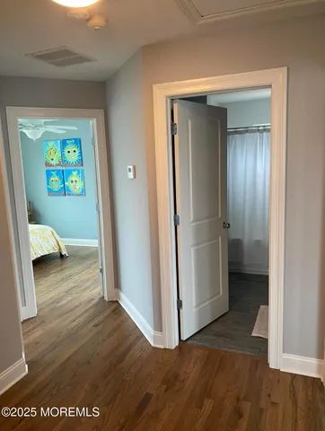 a view of a hallway with wooden floor and closet
