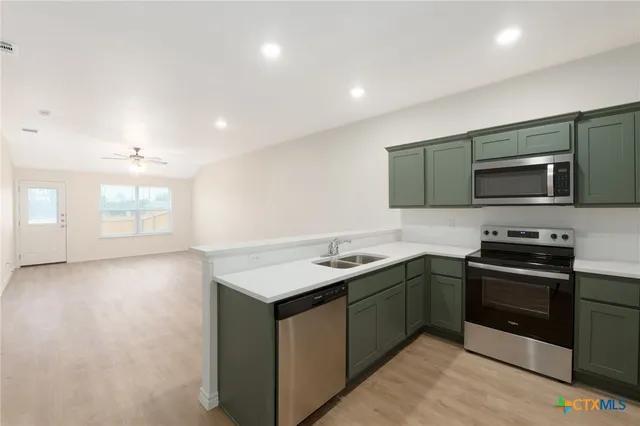 a kitchen with a sink and steel appliances