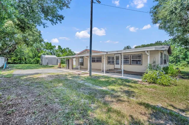 a view of a house with backyard porch and sitting area