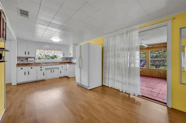 a view of a kitchen with wooden floor and electronic appliances