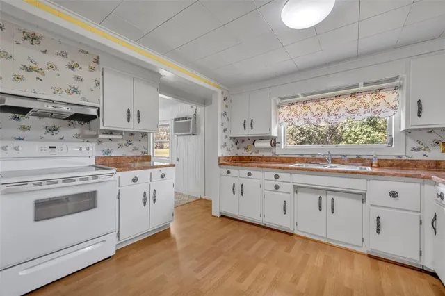 a kitchen with granite countertop white cabinets and white appliances