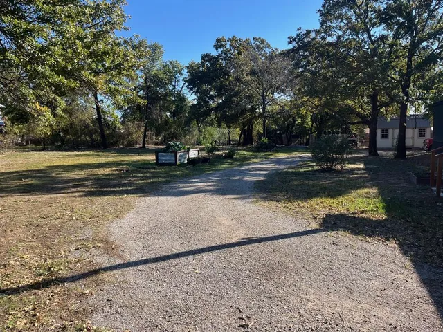 a view of dirt yard with a trees