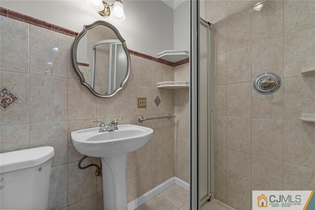 33 Hazel Avenue Edison, NJ 08820 - Photo 21 of 52 a bathroom with a sink a toilet and a mirror