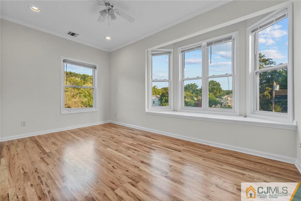 33 Hazel Avenue Edison, NJ 08820 - Photo 34 of 52 a view of an empty room with a window and wooden floor