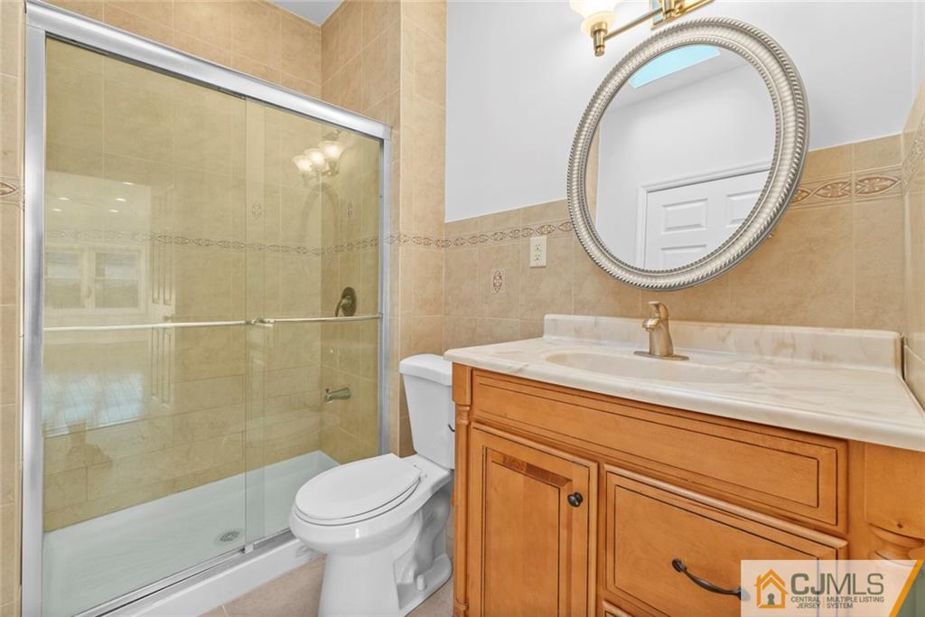 33 Hazel Avenue Edison, NJ 08820 - Photo 36 of 52 a bathroom with a sink a toilet and a mirror