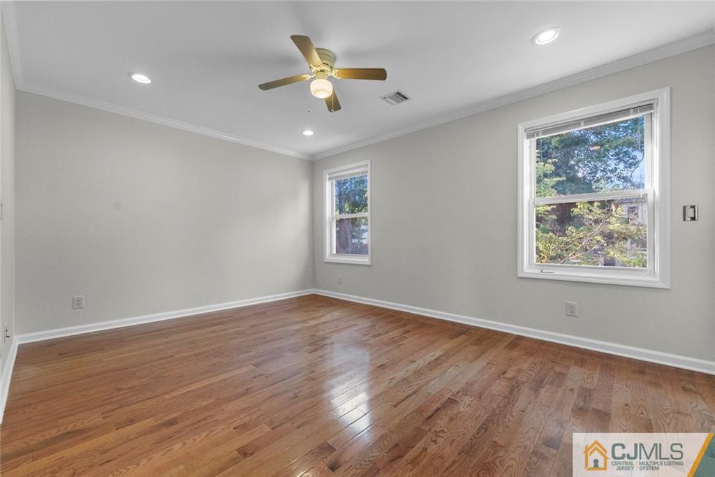 33 Hazel Avenue Edison, NJ 08820 - Photo 43 of 52 a view of an empty room with a window and wooden floor