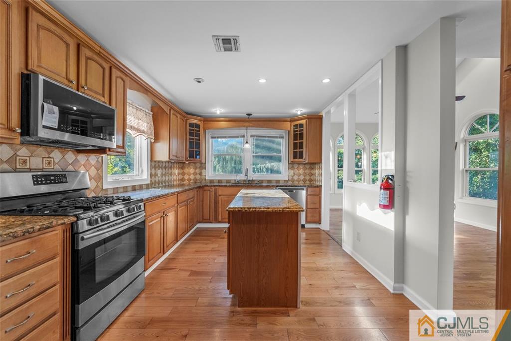 33 Hazel Avenue Edison, NJ 08820 - Photo 10 of 52 a kitchen with stainless steel appliances granite countertop wooden cabinets a stove top oven a sink and dishwasher