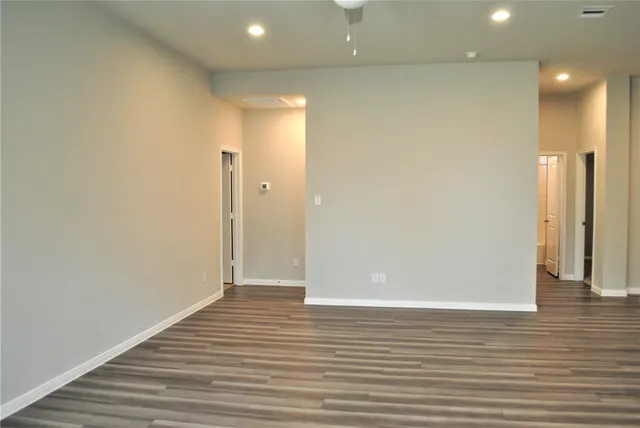 a view of an empty room with wooden floor
