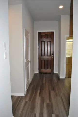 a view of a livingroom with wooden floor and a kitchen