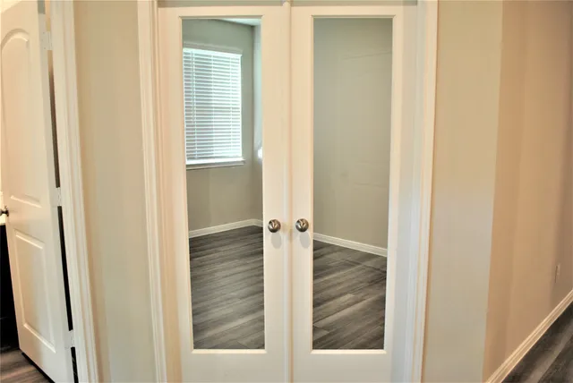 an empty room with wooden floor and a window