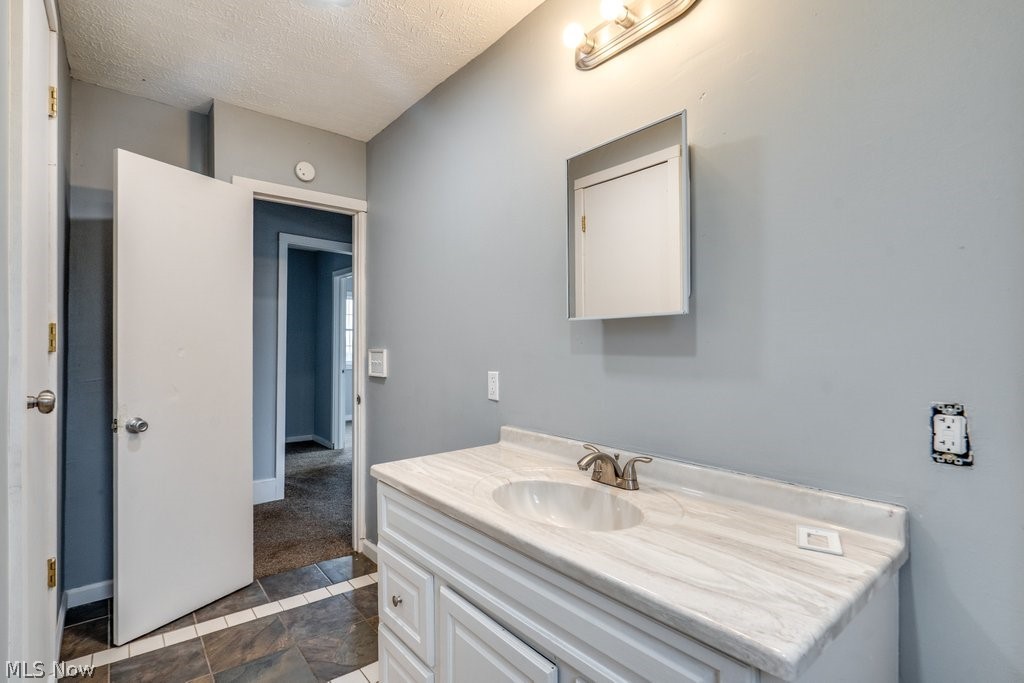 1607 9th Street Southwest Canton, OH 44706 - Photo 31 of 41 Bathroom vanity featuring a white cabinet base, integrated sink, and a light-toned countertop
