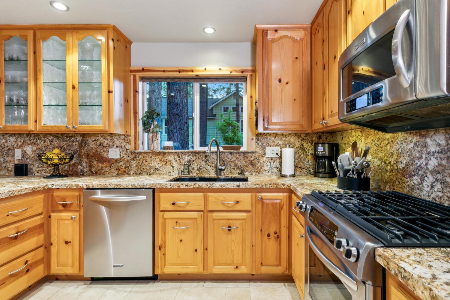 817 Kiowa Drive South Lake Tahoe, CA 96150 - Photo 19 of 39 a kitchen with granite countertop a stove a sink and a wooden cabinets