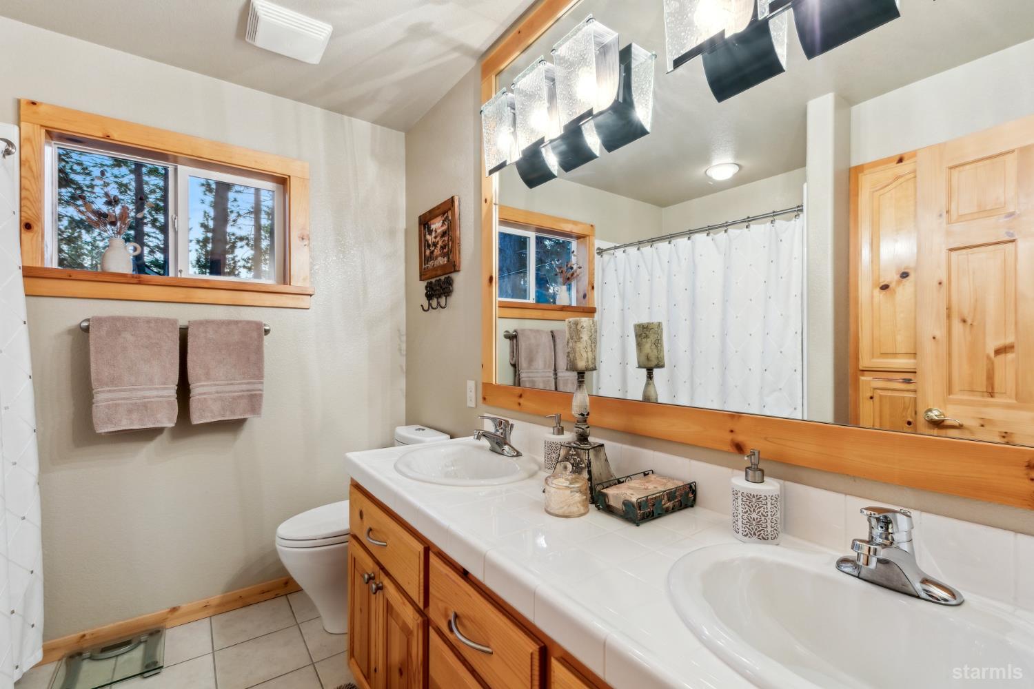 817 Kiowa Drive South Lake Tahoe, CA 96150 - Photo 36 of 39 a bathroom with a sink a toilet and a mirror