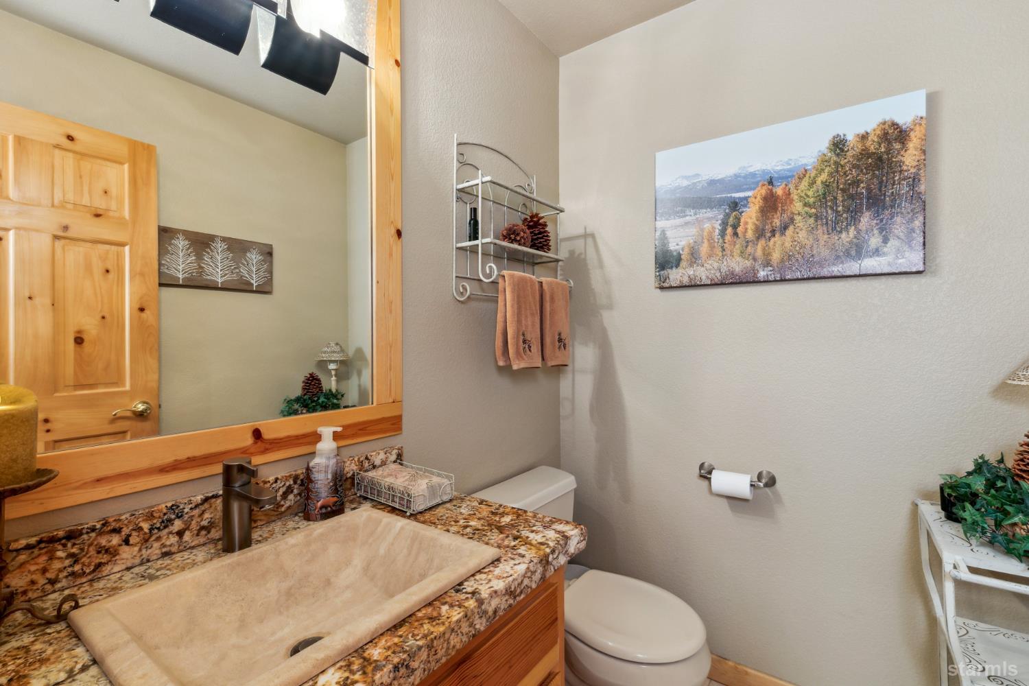 817 Kiowa Drive South Lake Tahoe, CA 96150 - Photo 37 of 39 a bathroom with a granite countertop sink mirror vanity and toilet