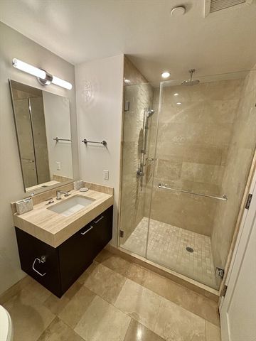 a bathroom with a sink mirror and shower