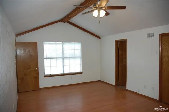 an empty room with windows and fan