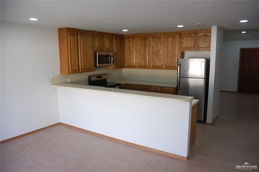 2401 South Jackson Road, Unit 26P Pharr, TX 78577 - Photo 3 of 15 a kitchen with stainless steel appliances a refrigerator a sink a stove a microwave and cabinets