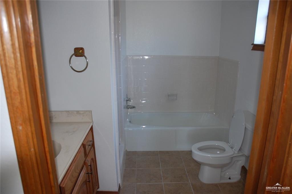 2401 South Jackson Road, Unit 26P Pharr, TX 78577 - Photo 7 of 15 a bathroom with a granite countertop toilet and a shower
