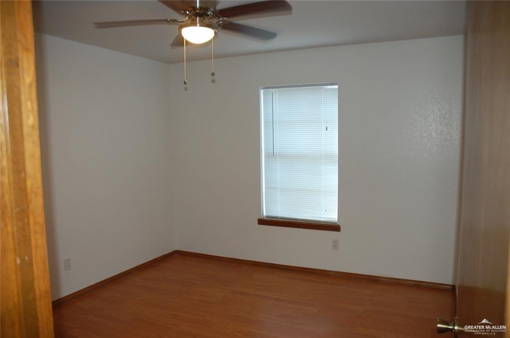 2401 South Jackson Road, Unit 26P Pharr, TX 78577 - Photo 9 of 15 an empty room with a chandelier fan and windows