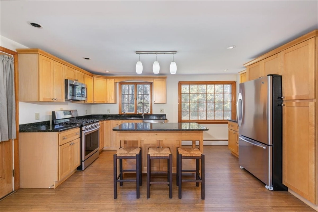 145 Warrenton Road Haverhill, MA 01832 - Photo 11 of 38 a kitchen with granite countertop a refrigerator a stove a sink dishwasher and white cabinets with wooden floor